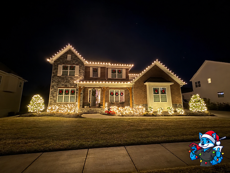 Two-story home with roofline and landscape Christmas display